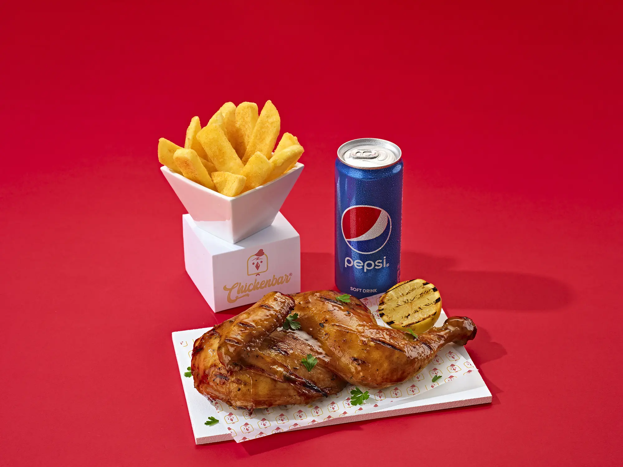 Half chicken with a side of chips and a can of pepsi