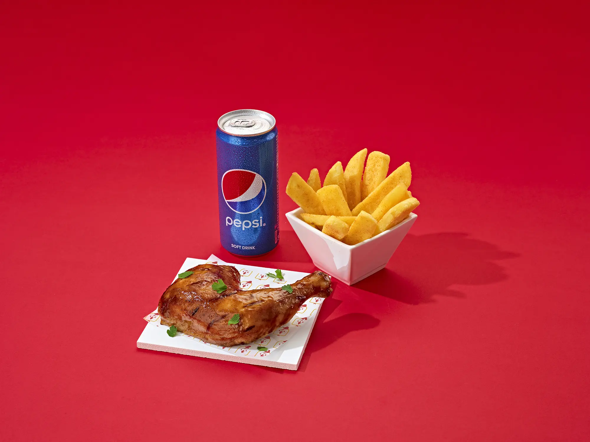 A quater leg chicken with a side of chips and a can of pepsi